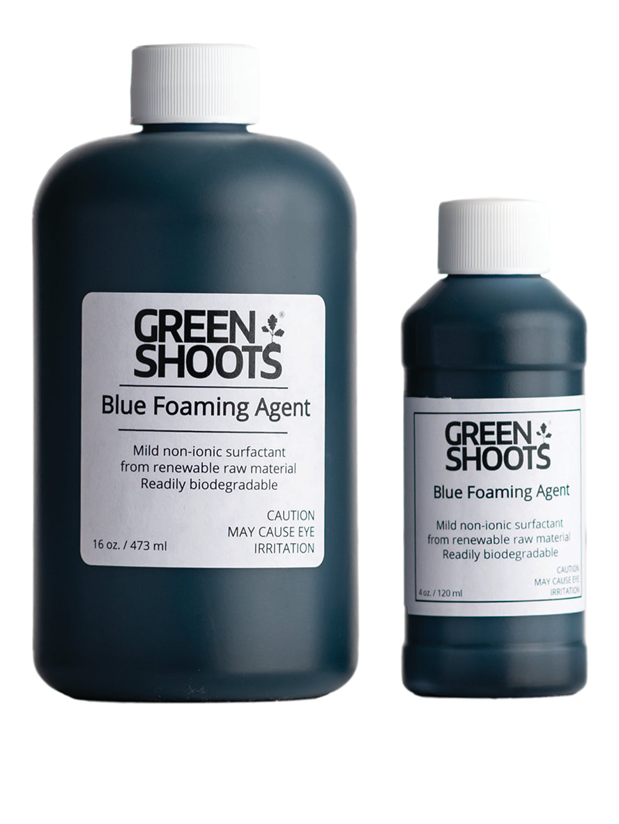 Two bottles of Blue Foaming Agent, one larger than the other, with labels indicating their use for herbicide treatment, biodegradability, and blue colorant.